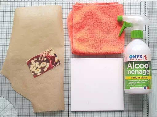 Espace de travail pour pâte polymère avec plaque de verre ou carreau de carrelage, papier sulfurisé et carte pour lisser, chiffon microfibre et alcool ménager