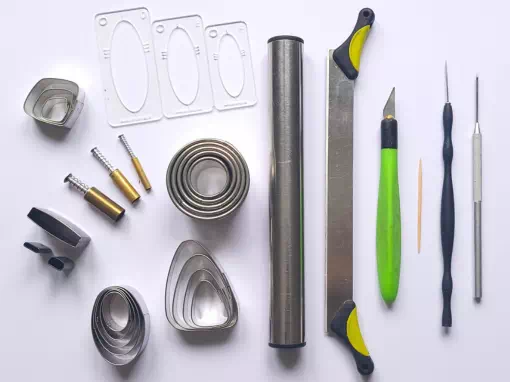 Outils essentiels pour débuter la pâte polymère : rouleau, lame, scalpel, emporte-pièces, gabarits, aiguille